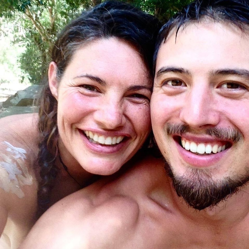 A man and a woman take a selfie with big smiles on their faces 