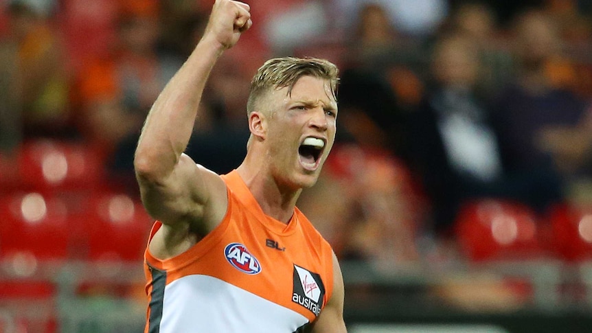 Greater Western Sydney Giants midfielder Rhys Palmer celebrates scoring a goal with his fist in the air.