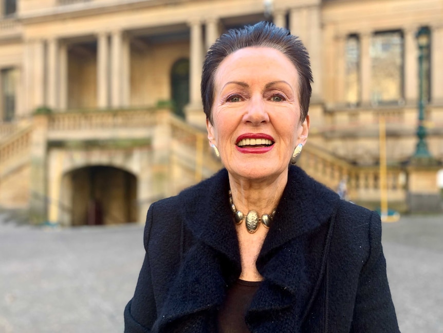 Sydney Lord Mayor Clover Moore stands in front of the city's Town Hall building.