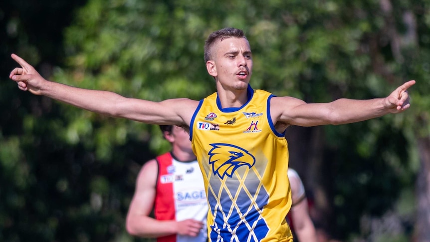 AFL draft prospect Joel Jeffrey holds out his arms in celebration in the AFL NT.