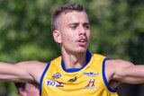 AFL draft prospect Joel Jeffrey holds out his arms in celebration in the AFL NT.