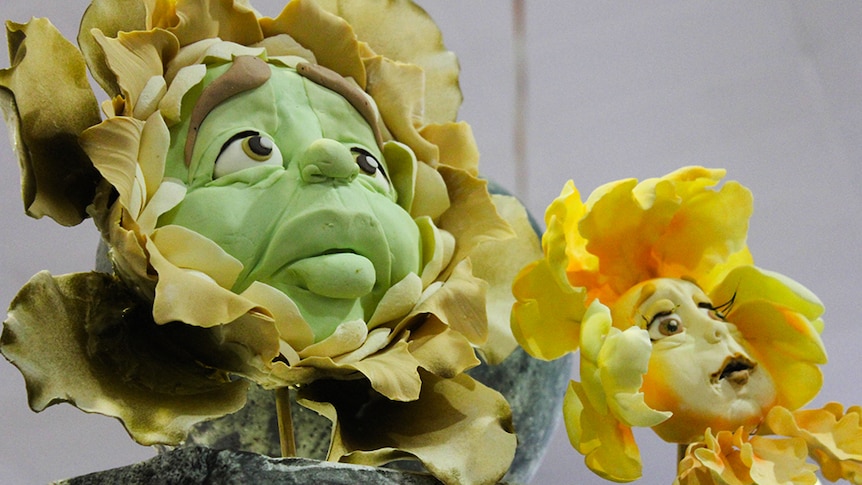 Two sugar sculptures of the flowers with faces from Alice in Wonderland.