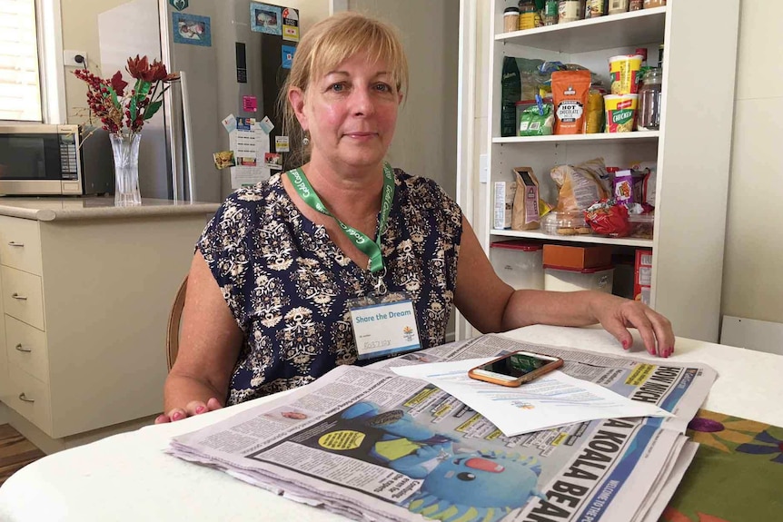 2018 Gold Coast Commonwealth Games volunteer Hermina Van Amstel sits at her coffee table with the newspaper.