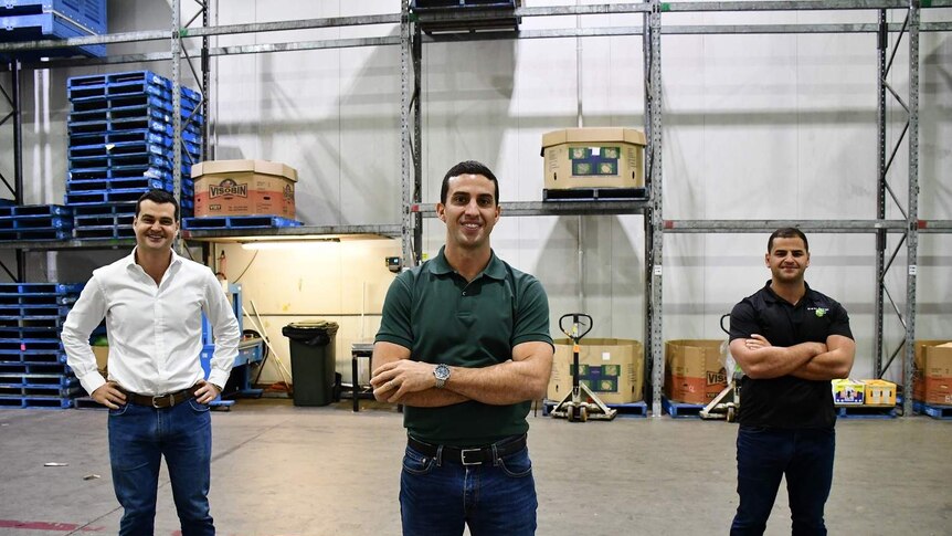 Jack, Ben and Matt George pose for photo inside empty warehouse.