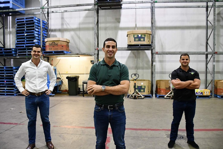 Jack, Ben and Matt George pose for photo inside empty warehouse.