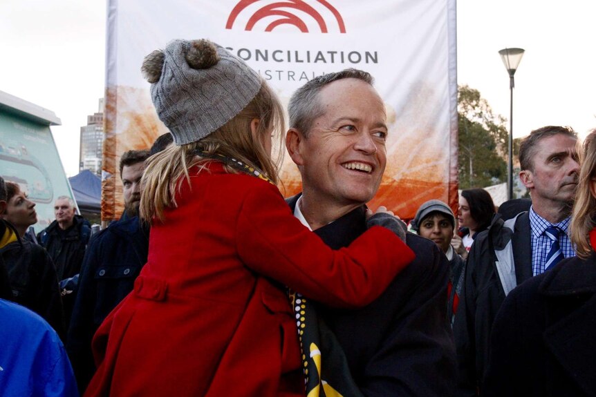 Bill Shorten carries his daughter Clementine while on the Long Walk.