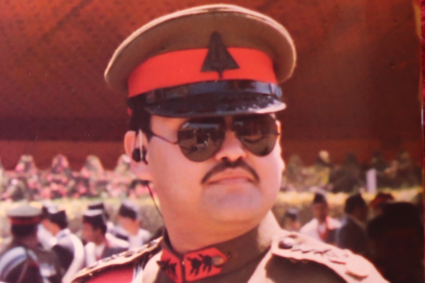 A Nepalese man with a moustache in a brown and red military uniform