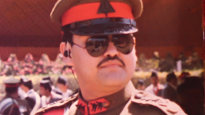 A Nepalese man with a moustache in a brown and red military uniform