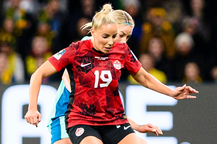 A Canadian player controls the ball against a Matildas opponent during the 2023 FIFA Women's World Cup.