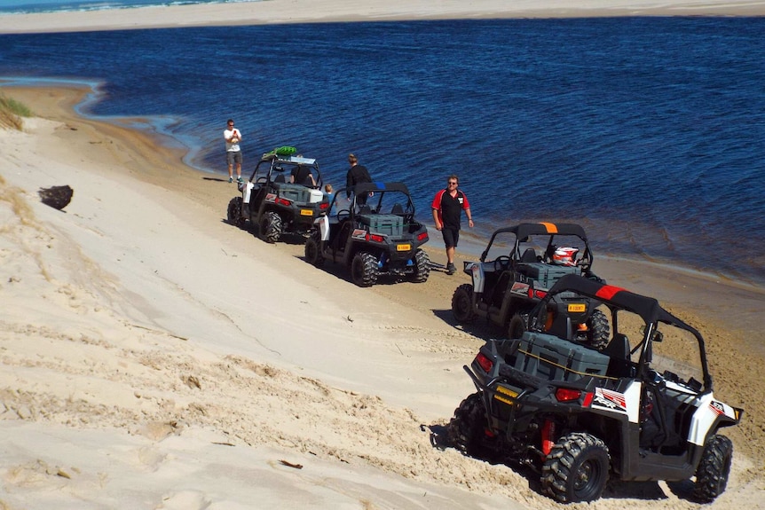 Ian Hall with vehicles on a  beach in Tasmania