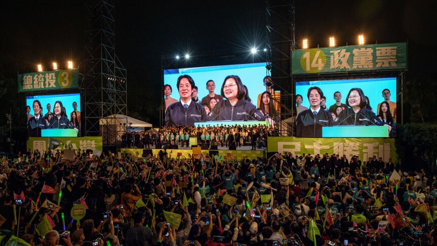 a stage surrounded by large screens show Tsai Ing-wen delivering a speech at a podium