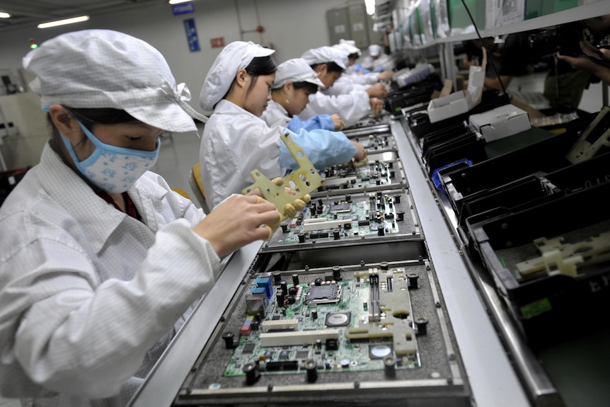 Chinese workers assembling electronic microchips.