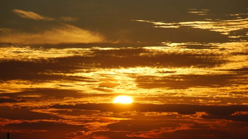 The sun's rays burst through the cloudcover as it sets at Parachilna, about 400km north of Adelaide in central-east SA, on May 12, 2009.