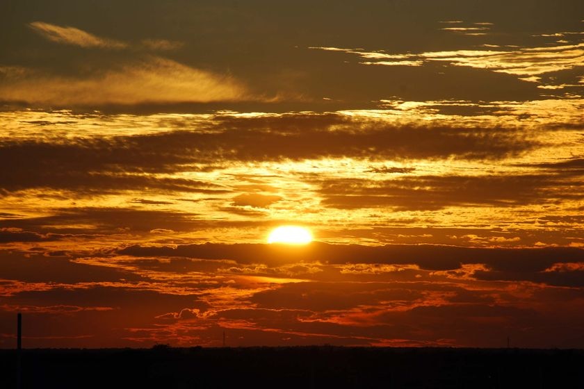 The sun's rays burst through the cloud cover as it sets at Parachilna, about 400km north of Adelaide in central-east SA.