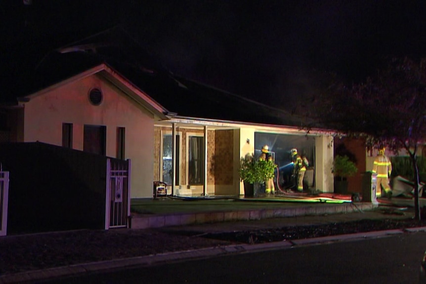 A house at night with firefighters out the front