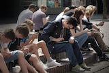 Young people in a group using mobile devices.