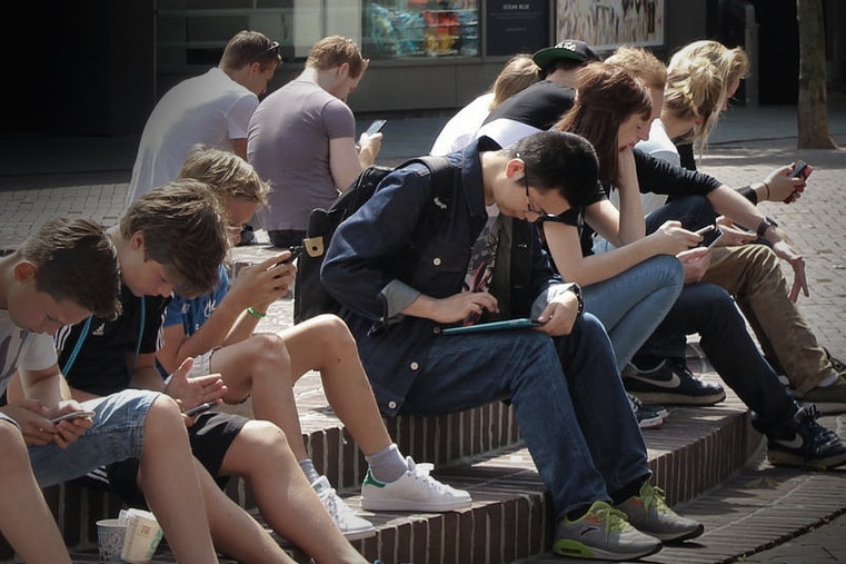 Young people in a group using mobile devices.