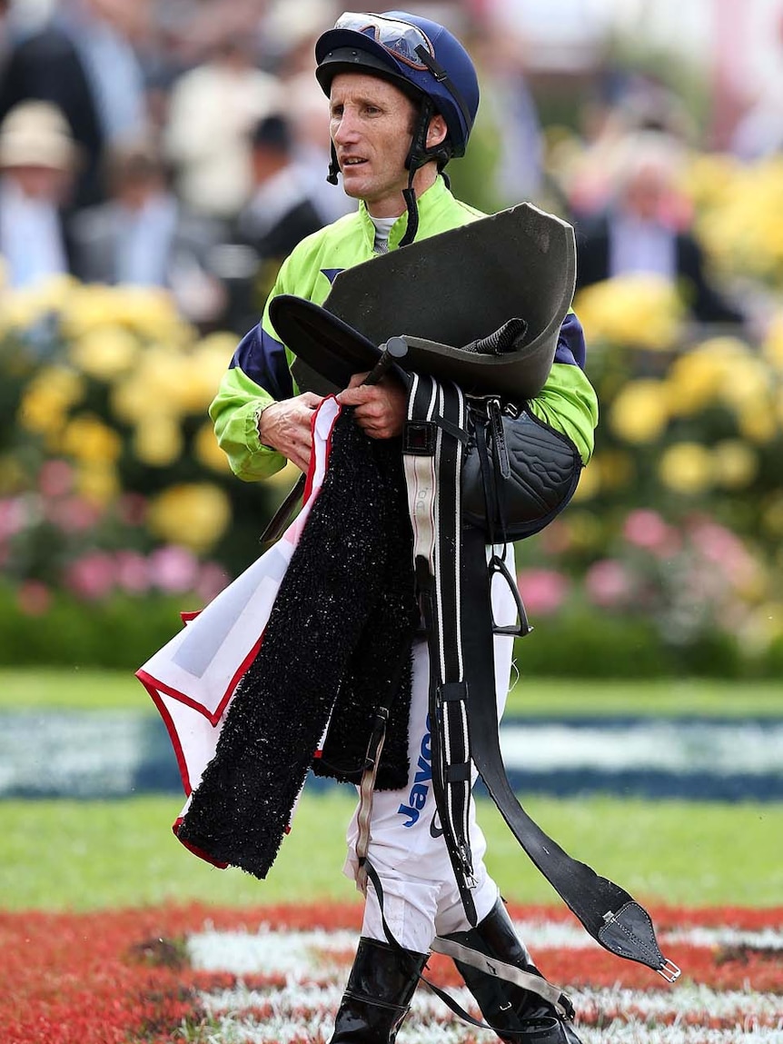 Damien Oliver walks through the mounting yard after arriving at Flemington racecourse this morning.