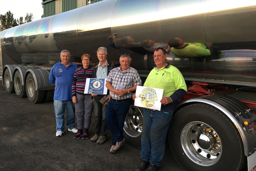 Upper Hunter resident Len Kelman pictured with his water truck and volunteers from Need For Feed and the Lions Club.