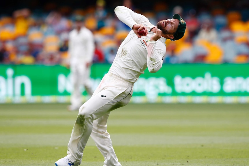 A cricketer falls backwards with the ball firmly in his hand as he takes the match-winning catch.