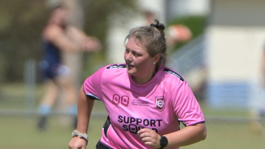 girl in pick top refereeing rugby league game 