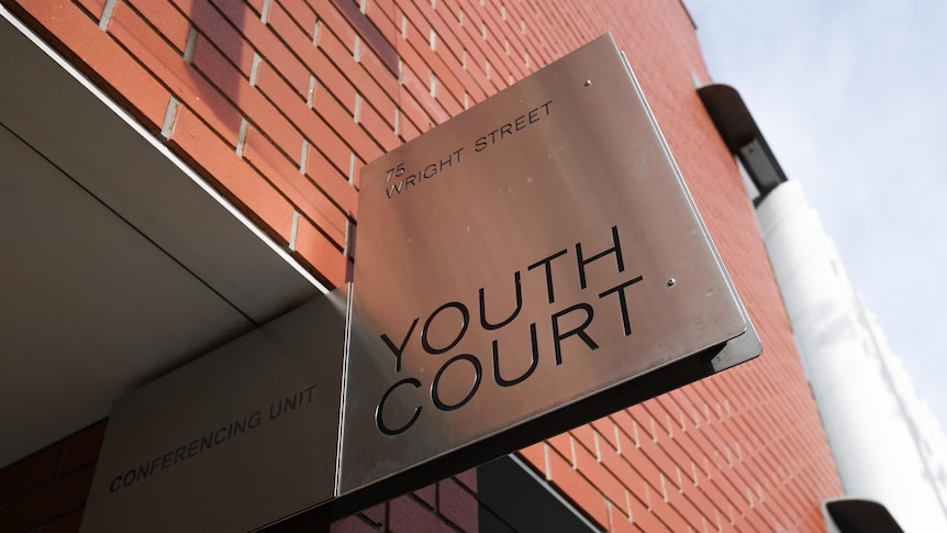 A metal sign on a building saying YOUTH COURT
