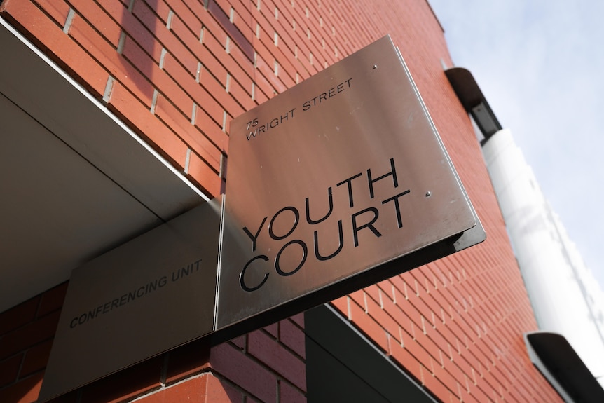 A metal sign on a building saying YOUTH COURT