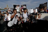 Activists hold up pictures of the 14 students who had been held for holding anti-coup protests, during a rally outside the military court in Bangkok, Thailand, July 7, 2015