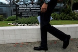 A man walks past a building sign showing Mossack Fonseca.