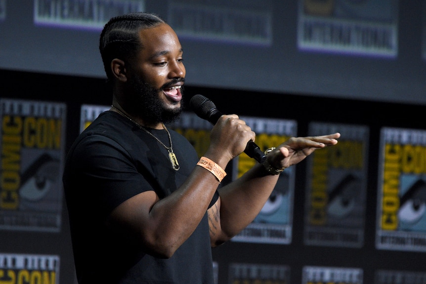Ryan Coogler holds a microphone as he speaks at the Comic-Con International