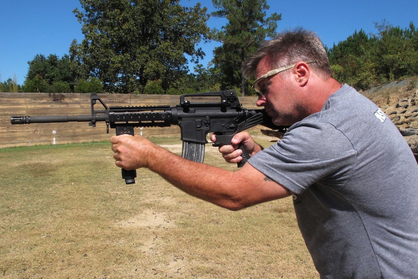 Shooting instructor Frankie McRae aims an AR-15 rifle fitted with a "bump stock"