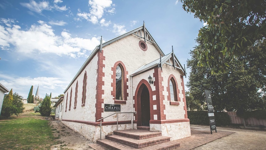 A beautiful old chapel with arched windows and careful brickwork stands on a leafy block in Naracoorte.