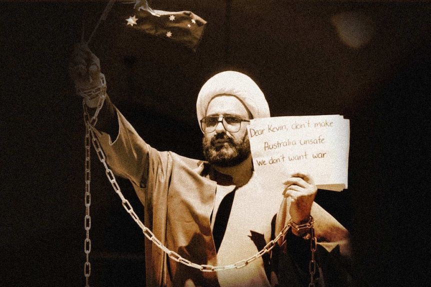 Monis as Sheikh Haron holding an Australian flag with sign to Kevin Rudd.