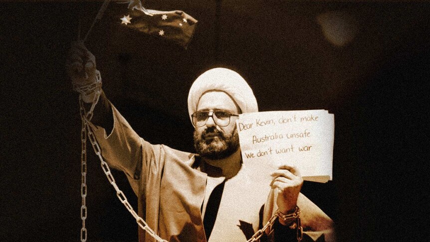 Monis as Sheikh Haron holding an Australian flag with sign to Kevin Rudd.