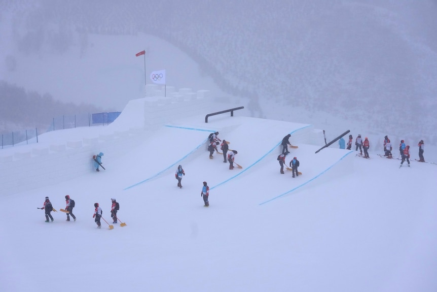 Volunteers clear the course at slopestyle