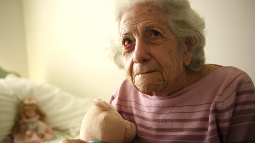 Portrait of an elderly lady clutching her teddy.