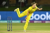 An Australian bowler looks down the pitch in her follow-through after delivering the ball in a T20 international. 