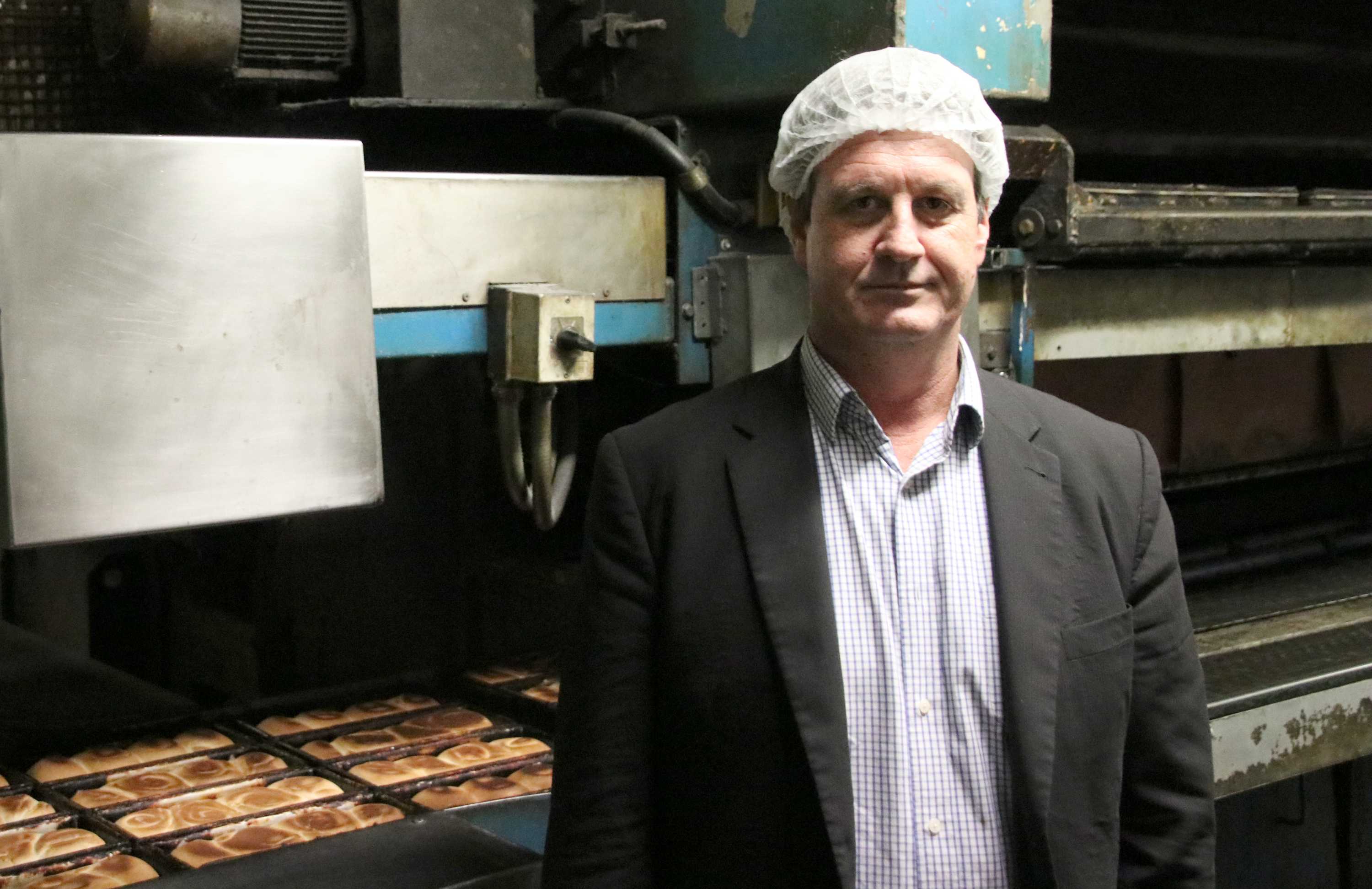 Midas bakery owner Conrad Mias standing in front of bakery machinery