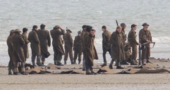 A scene from the movie Dunkirk shows soldiers on a beach.