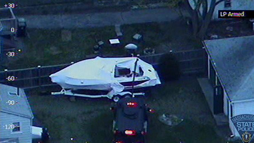 An aerial image shows police using a robotic arm to search the boat where suspected Boston bomber Dzhokhar Tsarnaev was hiding.