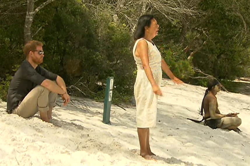 Prince Harry sits and watches as a welcome to country ceremony is conducted at Lake McKenzie on Fraser Island.