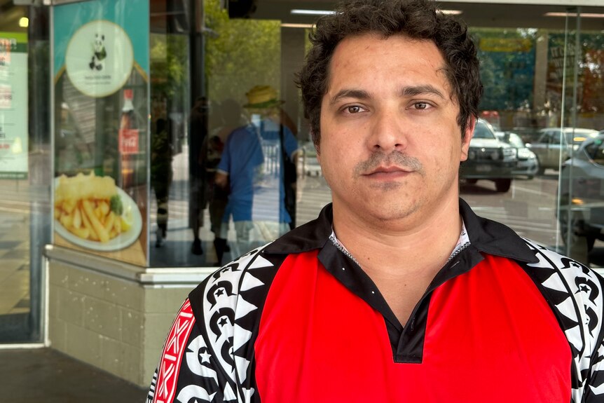 a torres strait man wearing a red collared t-shirt