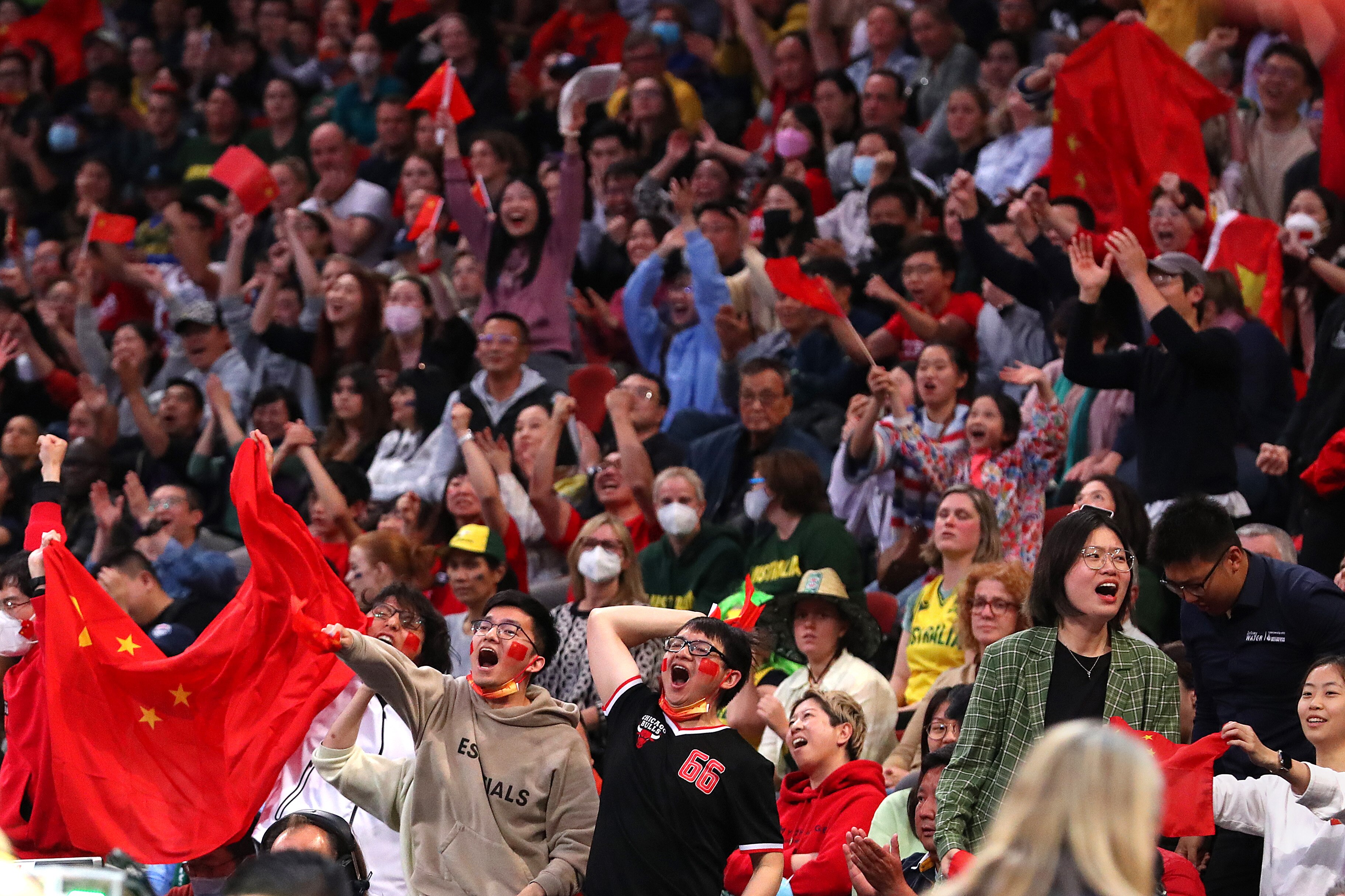 Fans cheer and wave red China flags