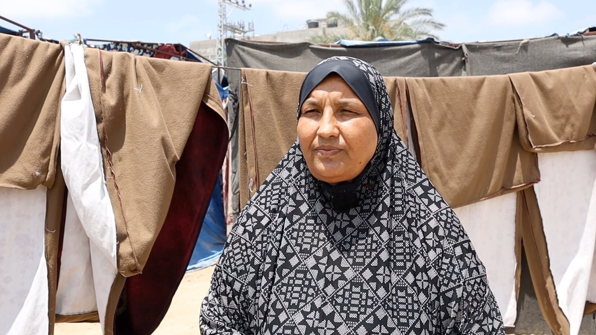 A woman in front of a clothes line. 