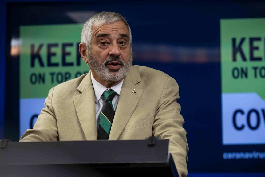 A man speaks at a lectern during a press conference.