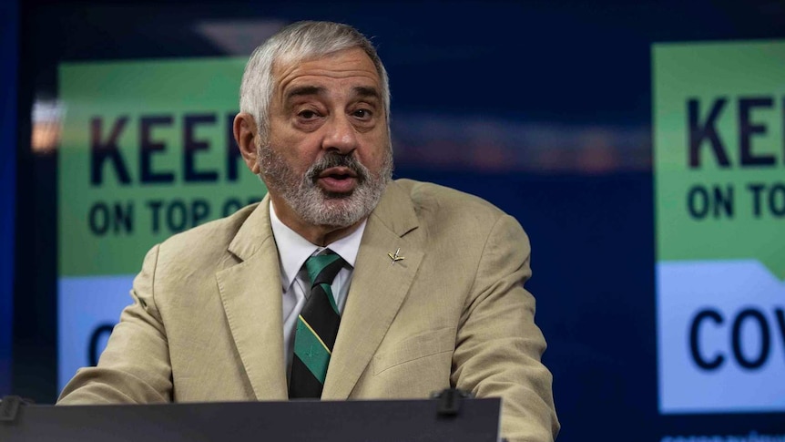 A man speaks at a lectern during a press conference.