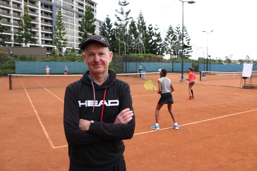 Jim Joyce at the Tennyson Tennis centre with players in the background.