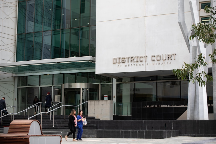 Two people walk past the entrance to WA's District Court.