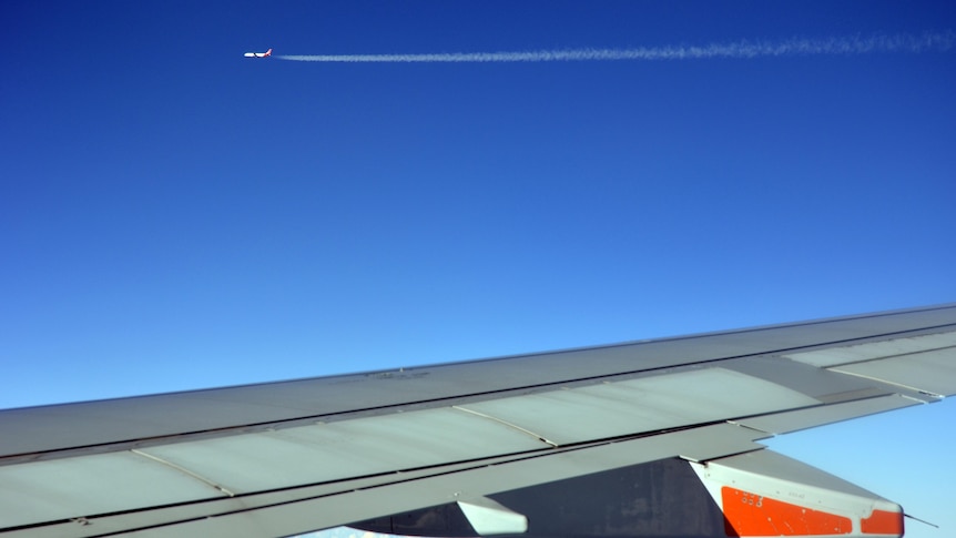 A plane leaves a contrail in its wake.