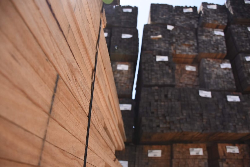 A close up of a stack of wooden boards with larger stacks in background at the Heyfield timber mill in Victoria in March 2017.